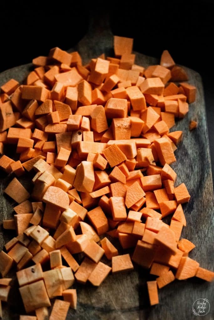 peeled and diced sweet potatoes on a cutting board