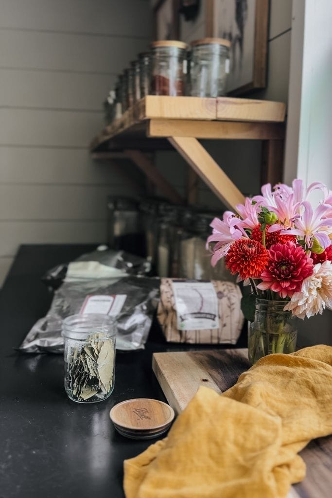 a jar filled bay leaves that are part of some pantry staples sitting on a counter