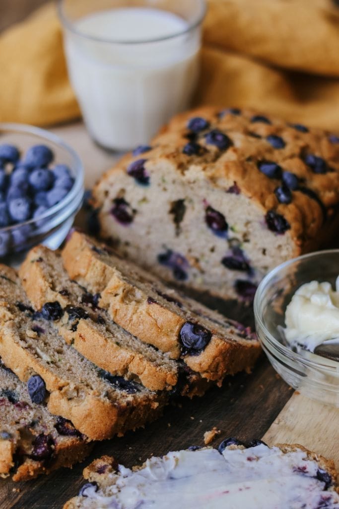 A sliced loaf of zucchini blueberry bread