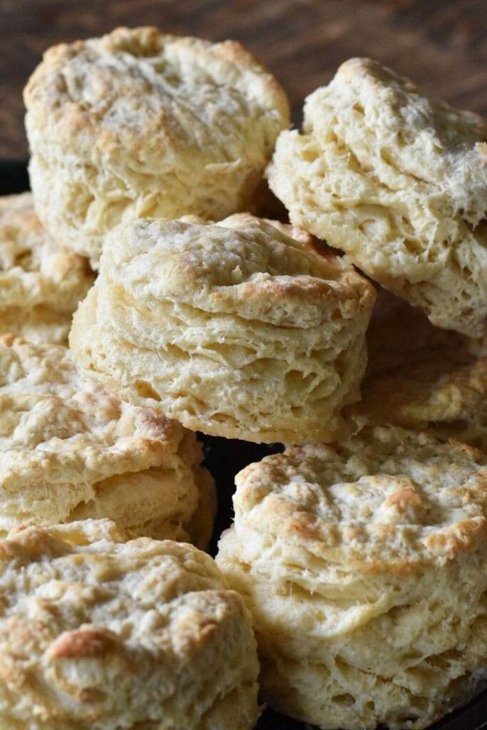 fluffy buttermilk biscuits in a stack on a cast iron skillet