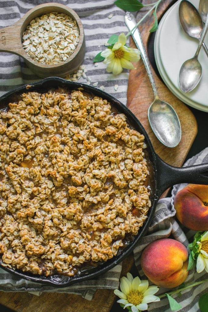 baked peach crisp in a cast iron skillet