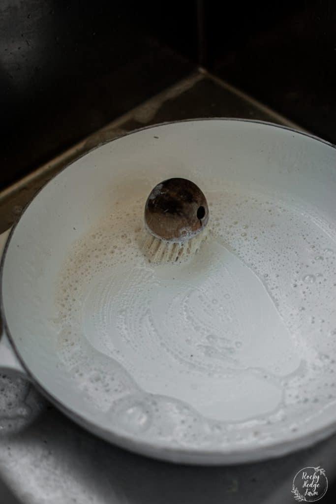 Using a wooden dish scrubber to clean enameled cast iron