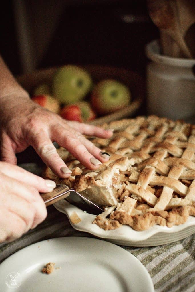 Lifting a slice of maple apple pie out the pan.