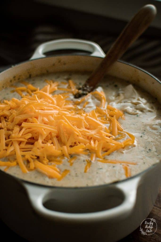 dutch oven filled with homemade potato soup and topped with cheese