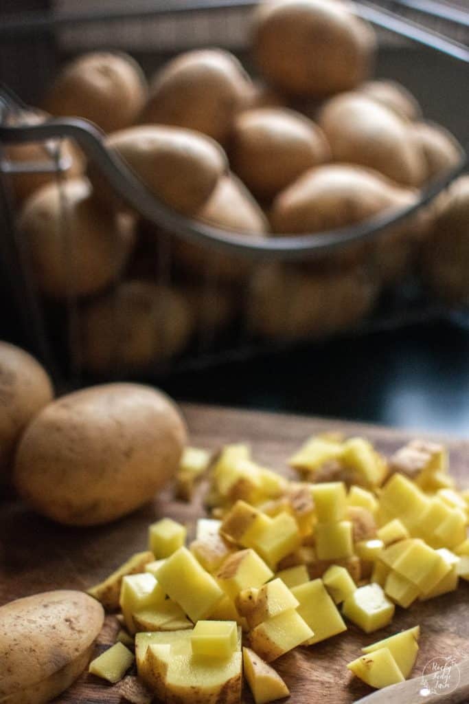 Peeled and diced potatoes on a cutting board