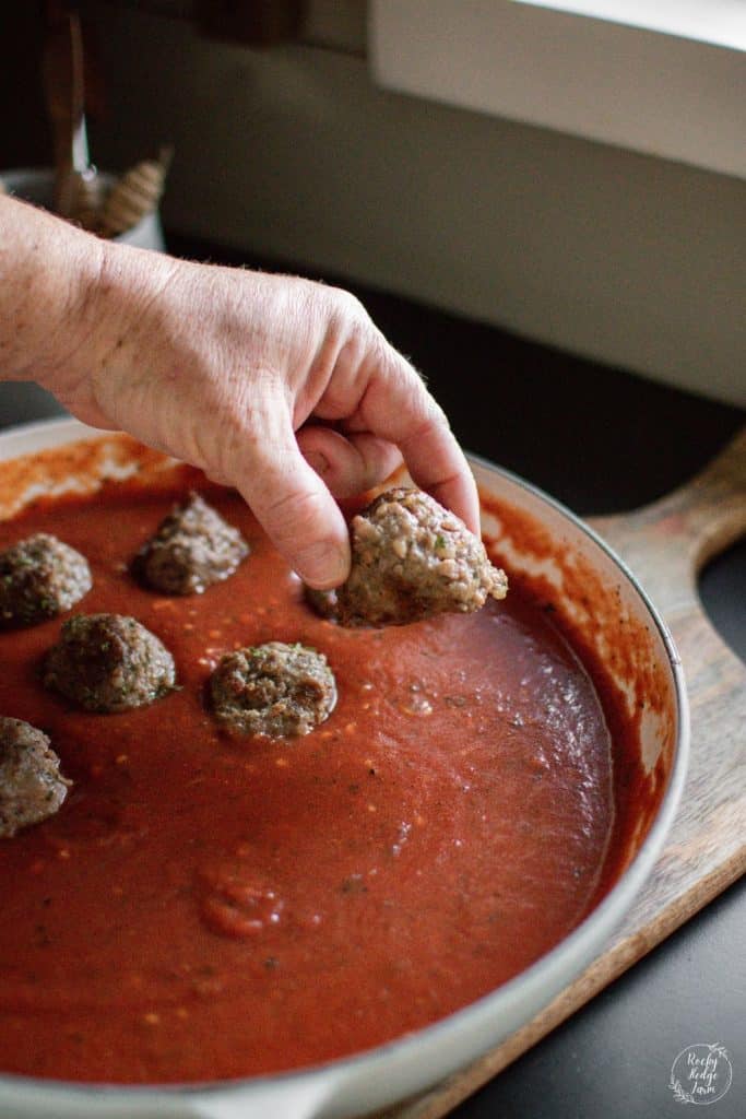 Adding old fashioned Italian meatballs to homemade tomato sauce marinara recipe.