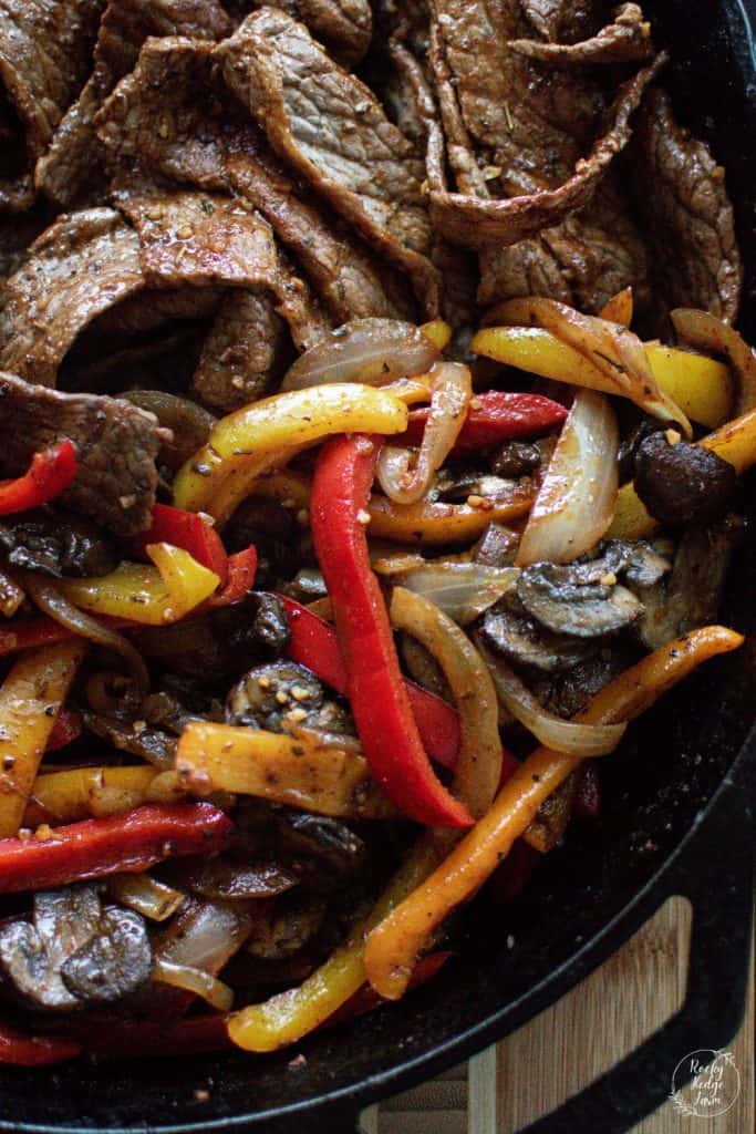 Cast iron skillet filled with steak and vegetables for fajitas