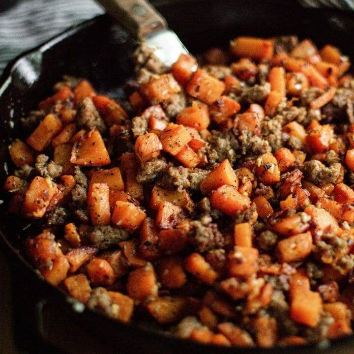 sausage and sweet potato hash in a cast iron skillet