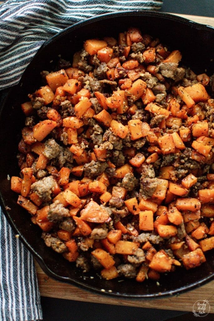sweet potato and sausage hash in a cast iron skillet
