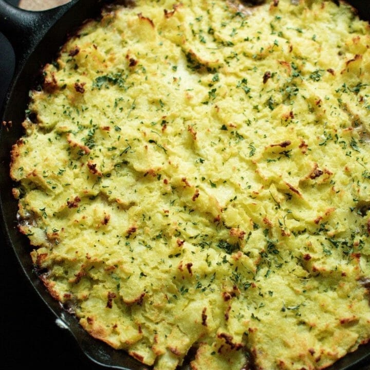 A delicious and hearty Shepherd's Pie in a cast iron skillet, topped with creamy mashed potatoes.