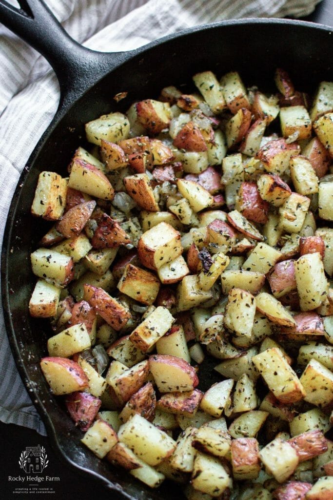 An appetizing sight of roasted potatoes and onions served in a cast iron skillet