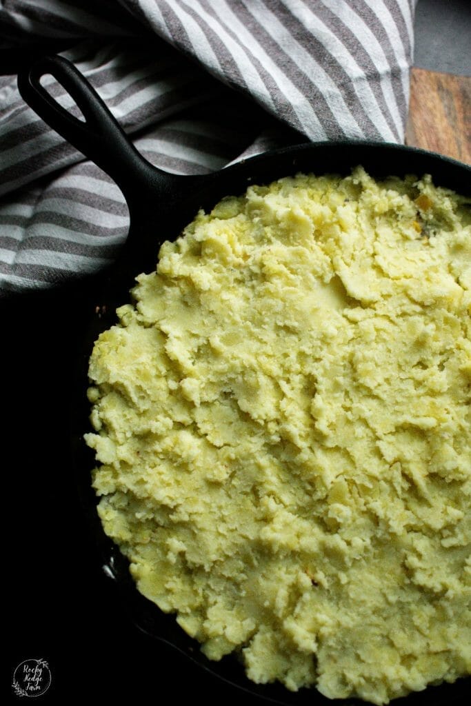 a layer of mashed potatoes on top of the ground beef mixture and corn for shepherds pie