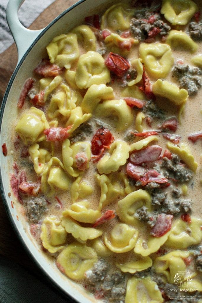 A delicious and easy-to-make skillet dish with creamy tortellini, Italian sausage, and spinach.