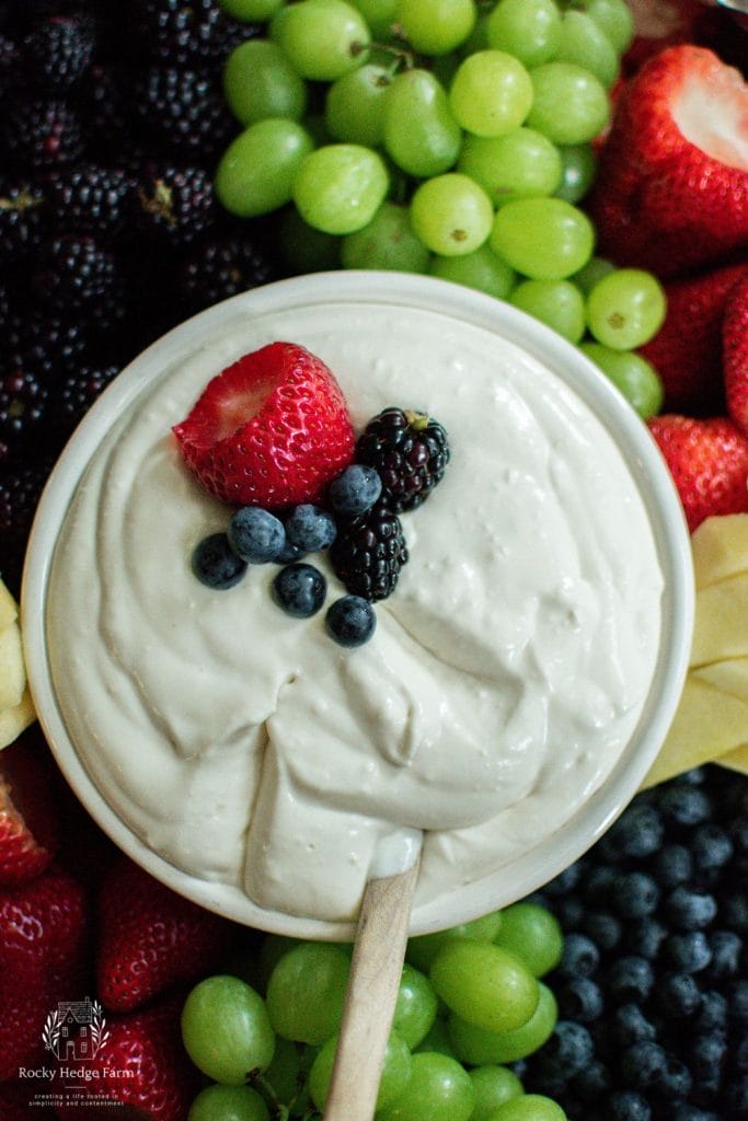 A white bowl filled with cream cheese fruit dip for a fruit platter