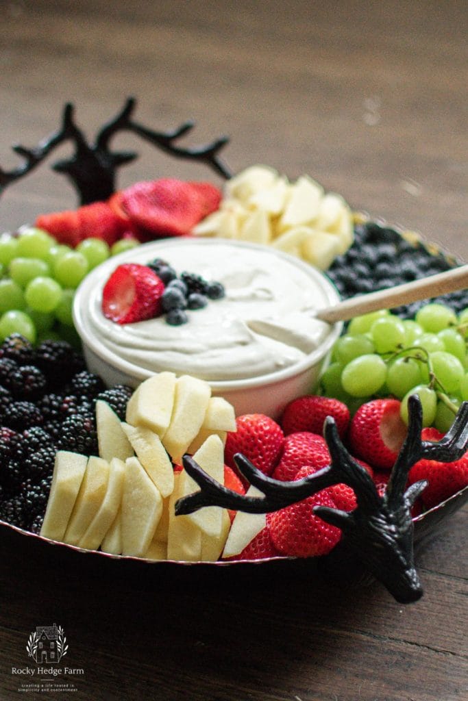 An eye-catching display of fresh fruit slices accompanied by a smooth cream cheese dip 