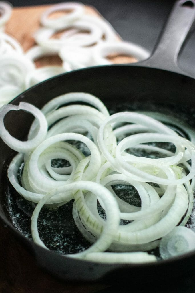 Sliced raw onions in cast iron skillet
