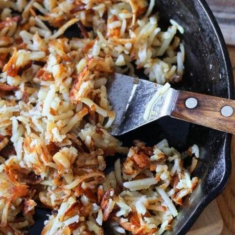 Cooked hash browns in a cast iron skillet