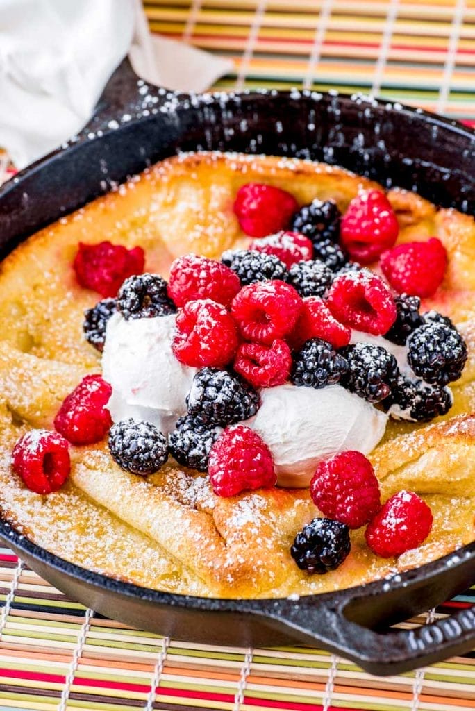 dutch baby pancake with berries in a skillet