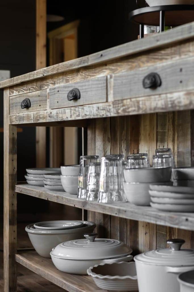 Open-concept kitchen featuring a reclaimed wood island with breakfast bar seating for two and convenient storage solutions within its shelves and drawers.