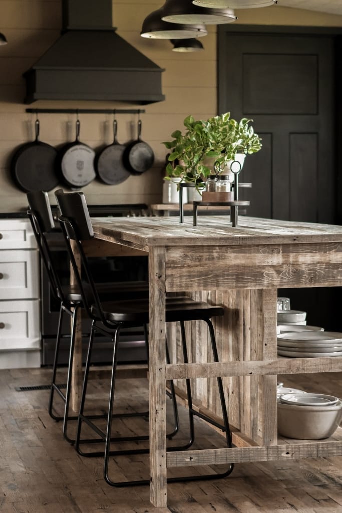 Open-concept kitchen featuring a distressed wood island with a breakfast bar for two.