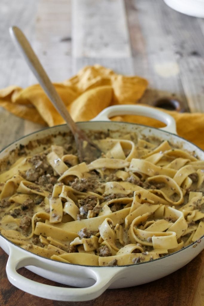 A skillet filled with creamy ground beef stroganoff with egg noodles, mushrooms, and onions.