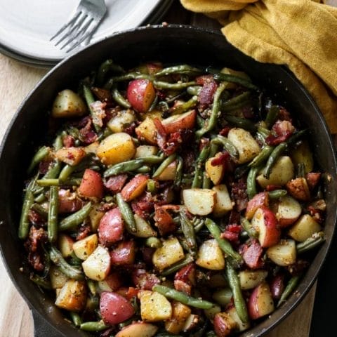 Simple summer side dish: Vibrant green beans and new potatoes in a cast iron skillet.