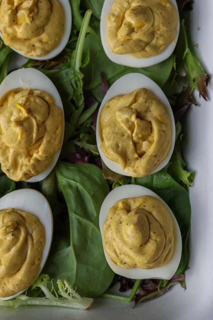 Deviled eggs filled with a creamy yellow yolk mixture, garnished with paprika.