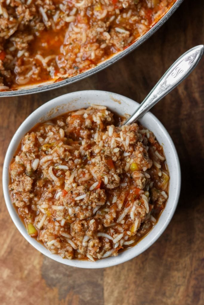 Round bowl filled with a savory ground beef and pepper skillet mixture. The dish includes cooked ground beef, diced peppers, rice, and tomato sauce.