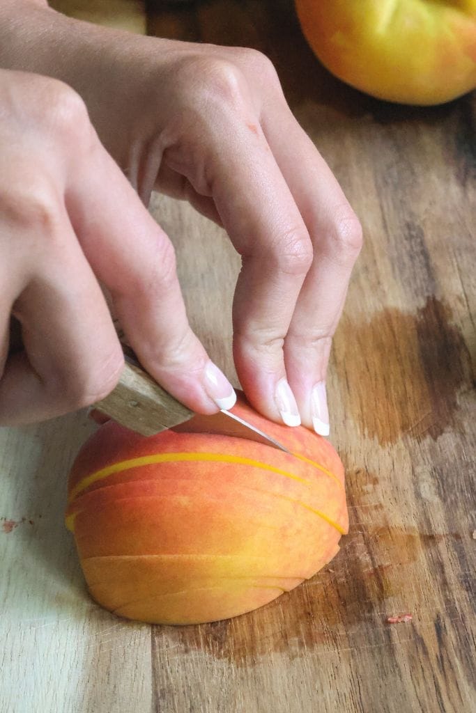 slicing a peach in slices for cobbler