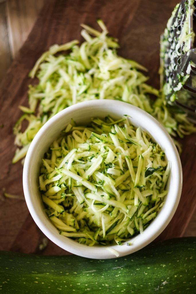 A white bowl with shredded zucchini in it