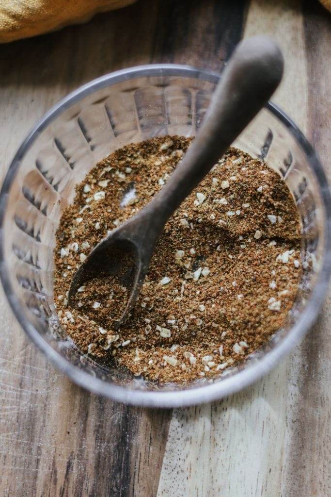 Spices for homemade taco seasoning, such as chili powder, cumin, and garlic powder, arranged in small bowls.