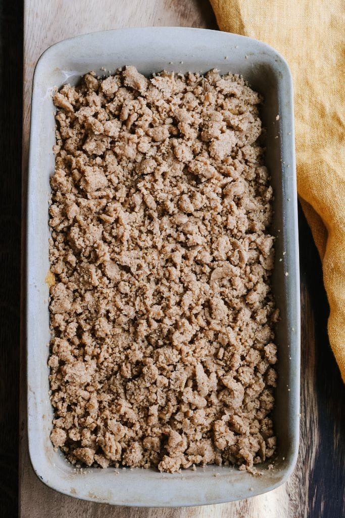 pumpkin bread in a loaf pan covered in streusel topping