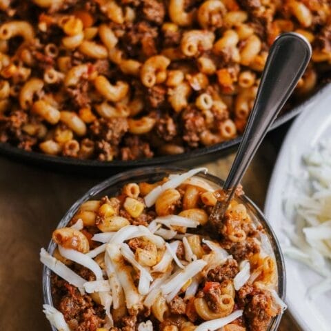 a glass bowl filled with southwest ground beef skillet recipe and topped with cheese