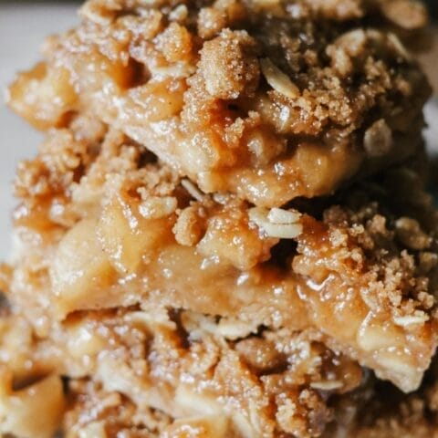 A stack of apple crisp bars sitting on a plate