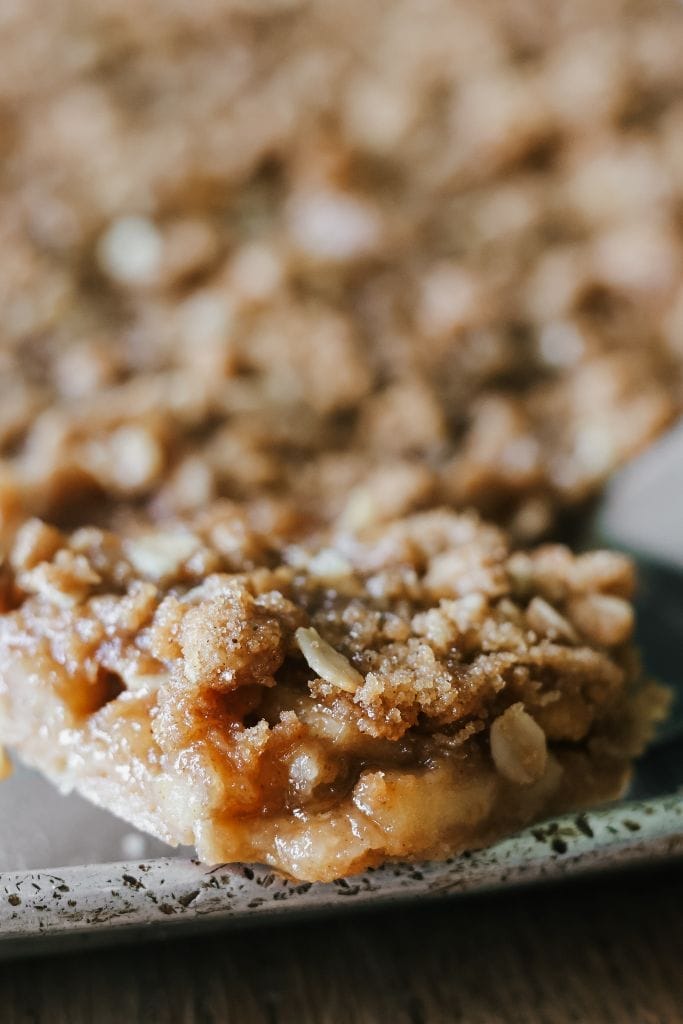 a close up of an apple crisp bar sitting on the edge of the baking sheet