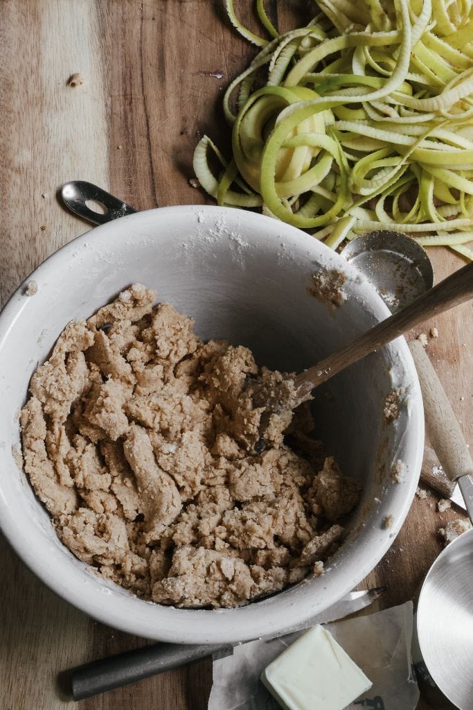 a bowl filled with the shortbread layer to make apple crisp bars