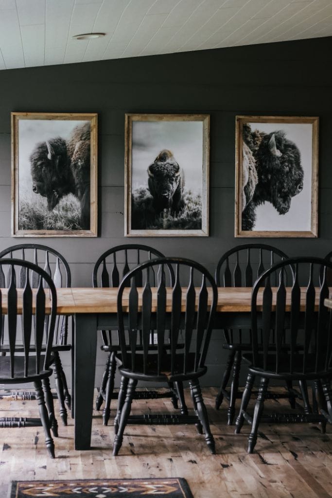 Deep, rich wall color creating a dramatic and inviting atmosphere in a cabincore-inspired dining room.