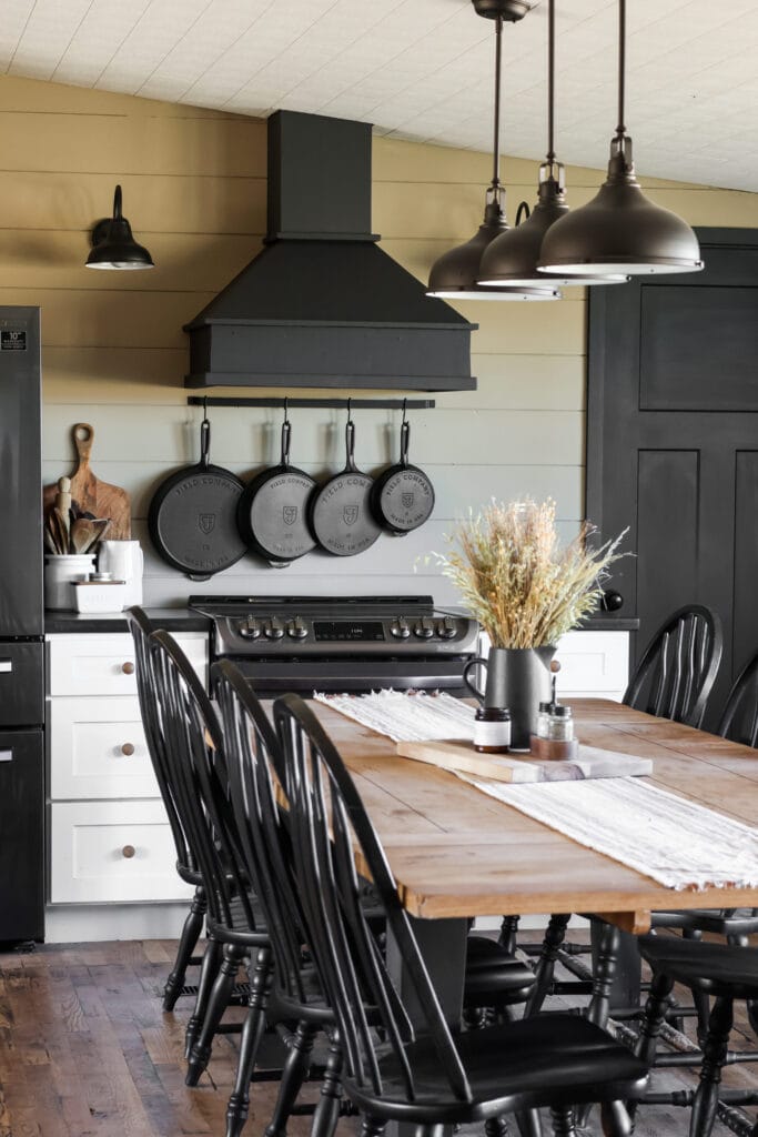 A kitchen with cast iron skillets hanging on the wall