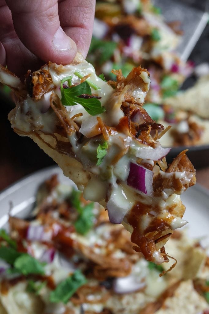 a close up of bbq nachos on a tortilla chip