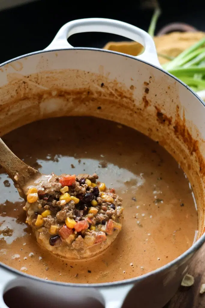 creamy taco soup in a dutch oven with a ladle full of the soup