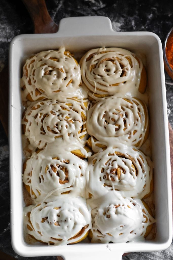 freshly baked cinnamon rolls with frosting in a pan