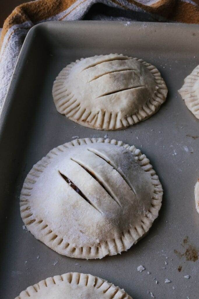 unbaked apple hand pie on a stoneware baking pan