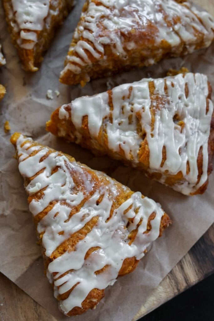 Freshly baked pumpkin scones with a smooth, glossy maple glaze, ready to be served.