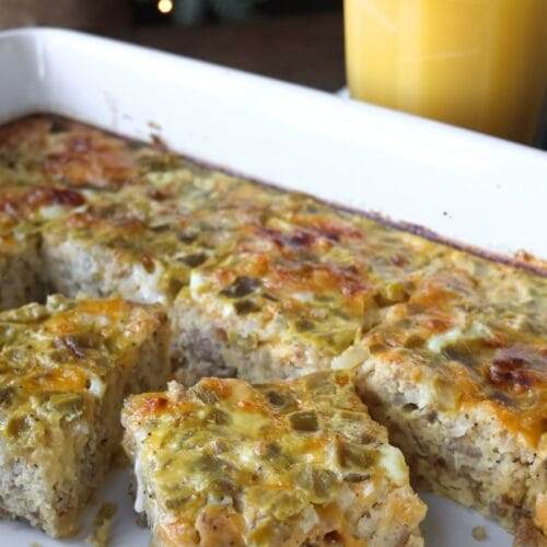 A close-up of a perfectly baked Sausage Hashbrown Breakfast Casserole with a golden, cheesy top, sliced and ready to serve.