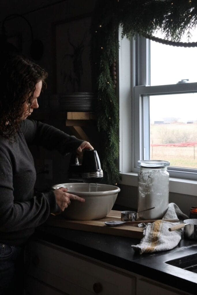 a person with a hand mixer, mixing the dough for peanut butter balls.