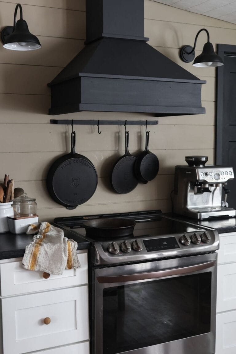 A cozy kitchen scene with cast iron skillets hanging on the wall