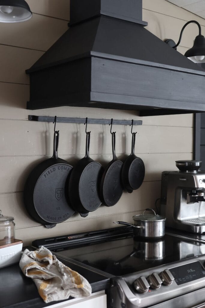 A row of cast iron skillets hanging above the stove. 